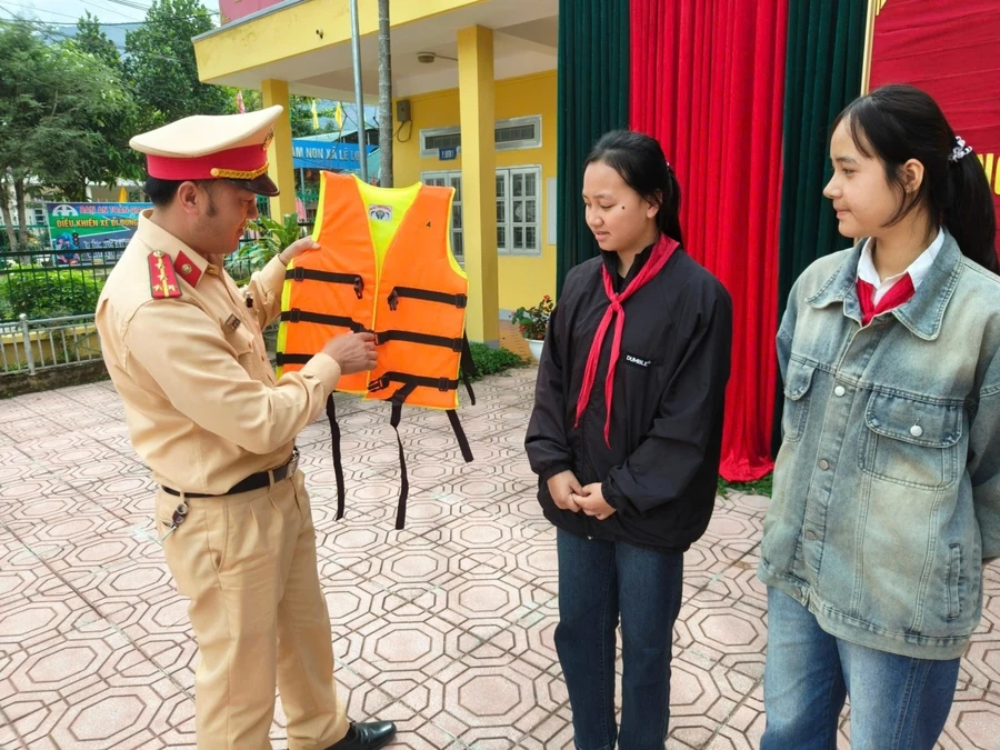 Cán bộ Phòng Cảnh sát Giao thông Công an tỉnh Lai Châu hướng dẫn học sinh cách sử dụng áo phao.
