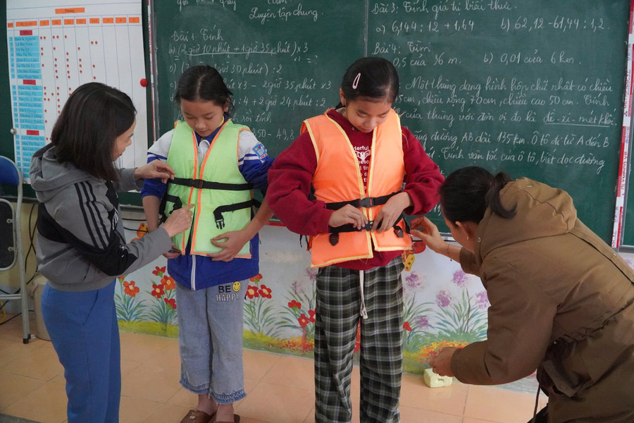 Giáo viên Trường PTDTBT Tiểu học xã Nậm Hàng hướng dẫn học sinh sử dụng áo phao đúng cách. lai-chau.jpg