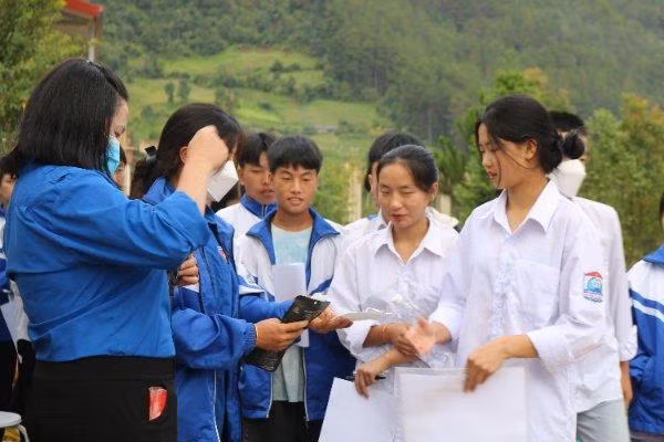 Tình nguyện viên hỗ trợ thí sinh vào phòng thi tại điểm thi Trường THCS&amp;THPT Púng Luông.