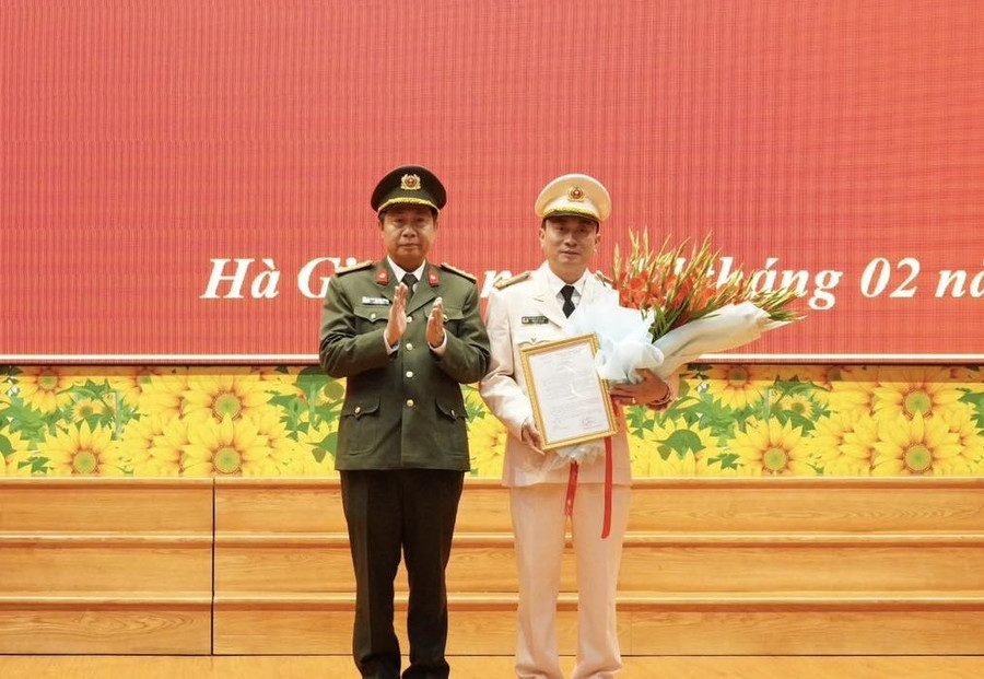 Đại tá Nguyễn Đức Thuận, Giám đốc Công an tỉnh Hà Giang trao quyết định và tặng hoa chúc mừng Thượng tá Nguyễn Mạnh Hùng.