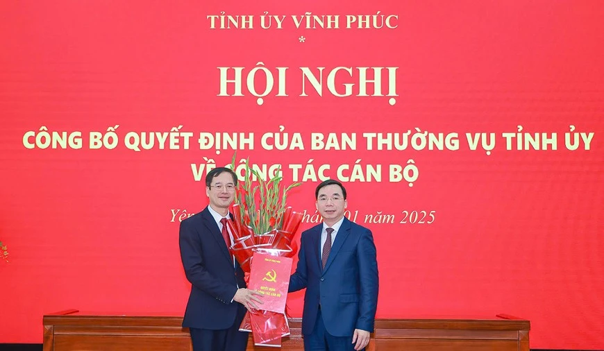 Phó Bí thư Thường trực Tỉnh ủy Vĩnh Phúc Bùi Huy Vĩnh (phải) trao Quyết định và tặng hoa chúc mừng ông Lại Hữu Tuyển.