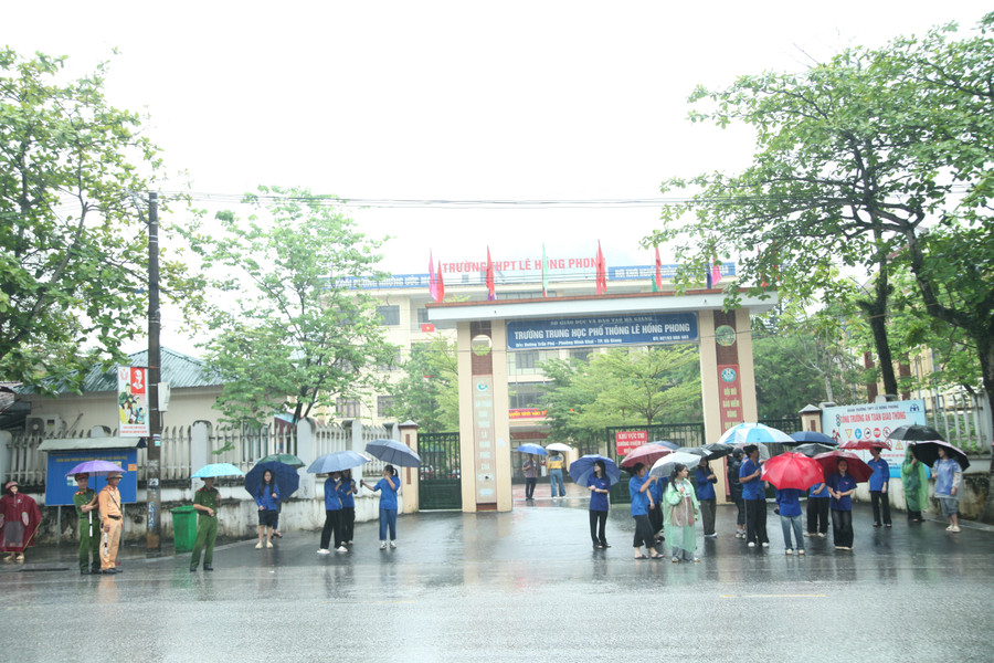 Các thí sinh đội mưa đến tham dự khi thi tại điểm thi Trường THPT Lê Hồng Phong, TP Hà Giang.