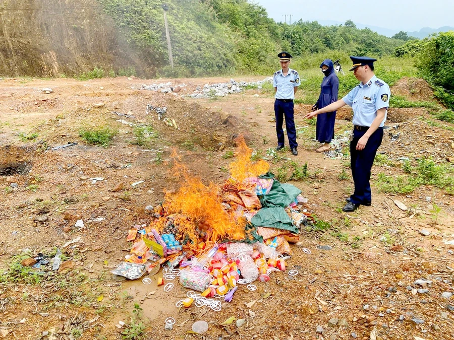 Lực lượng QLTT cùng chủ cơ sở kinh doanh tiến hành tiêu hủy số hàng hóa vi phạm.