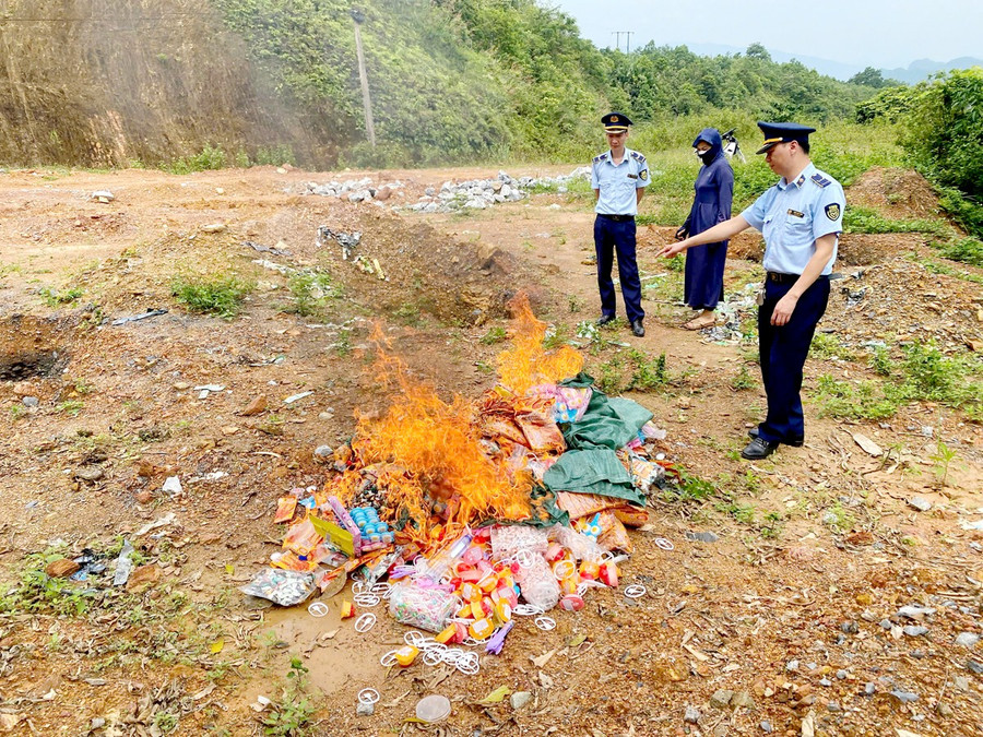 Lực lượng QLTT cùng chủ cơ sở kinh doanh tiến hành tiêu hủy số hàng hóa vi phạm.