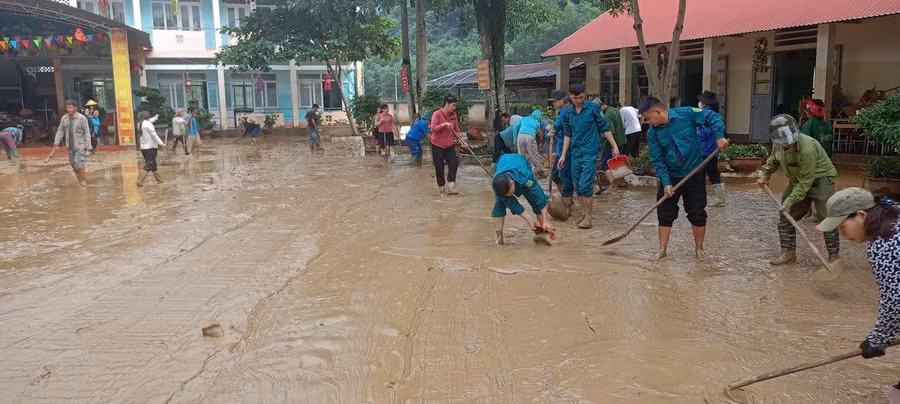 Lực lượng hỗ trợ nhà trường dọn dẹp sau khi nước rút.