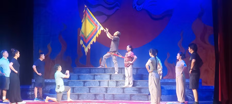 NSND Gia Khoản (cầm cờ), NSƯT Hồng Điểm (đứng sau) và các nghệ sĩ Nhà hát Tuồng Việt Nam tập trích đoạn vở 'Đề Thám'. Ảnh: Bình Thanh.