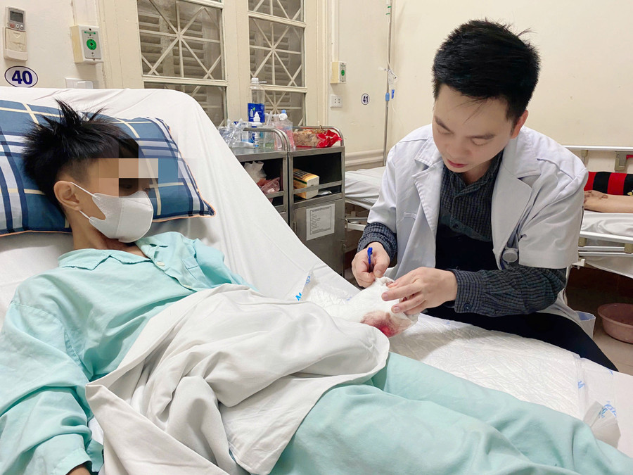 ThS.BS Nguyễn Văn Sự - Khoa Điều trị theo yêu cầu, Bệnh viện Hữu nghị Việt Đức thăm khám cho bệnh nhân 12 tuổi sau phẫu thuật.