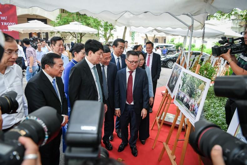 Ông Lê Quốc Minh - Tổng Biên tập Báo Nhân Dân giới thiệu với đoàn tham quan về bức ảnh họp lớp của cố Tổng Bí thư Nguyễn Phú Trọng dưới gốc cây đa 71 Hàng Trống vào năm 2022. Ảnh: BTC.