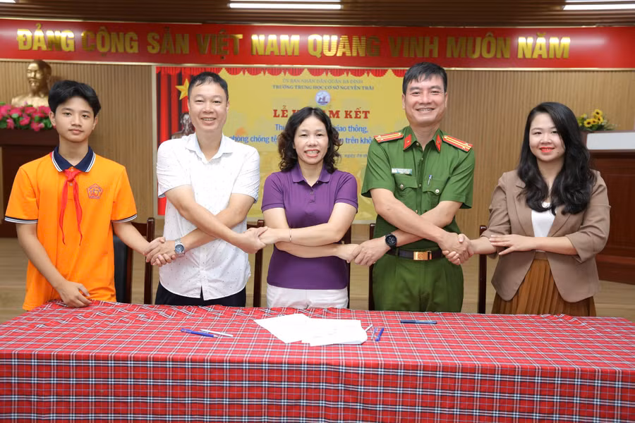 Học sinh Trường THCS Nguyễn Trãi (Hà Nội) nghe tuyên truyền và ký cam kết thực hiện ATGT.