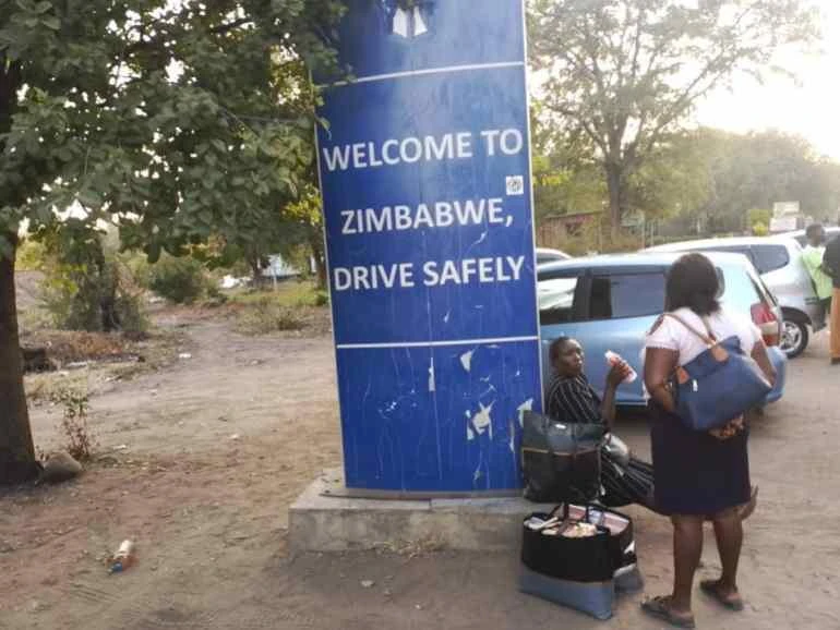 Người dân Zimbabwe ngồi nghỉ ở biên giới giữa Zimbabwe và Zambia.