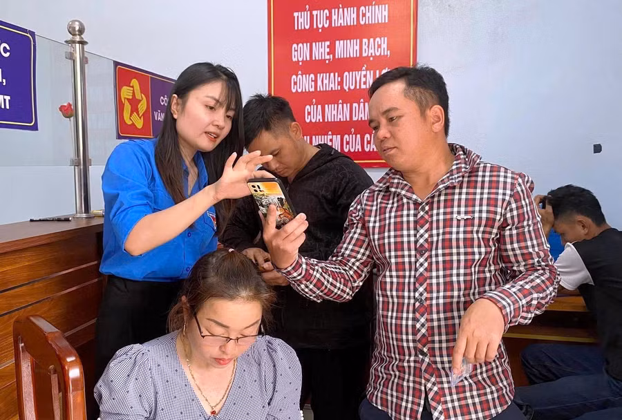 Lực lượng thanh niên xã Nam Xuân hướng dẫn người dân cài ứng dụng VNeID.