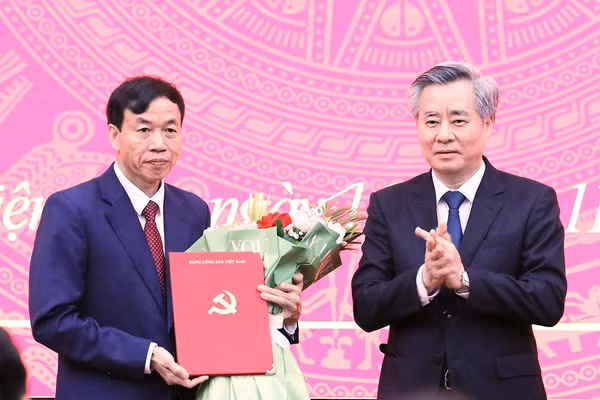 Ông Nguyễn Quang Dương, Phó trưởng Ban Tổ chức Trung ương (bên phải) trao Quyết định và tặng hoa chúc mừng ông Lê Văn Lương, Phó Bí thư Tỉnh ủy Điện Biên.