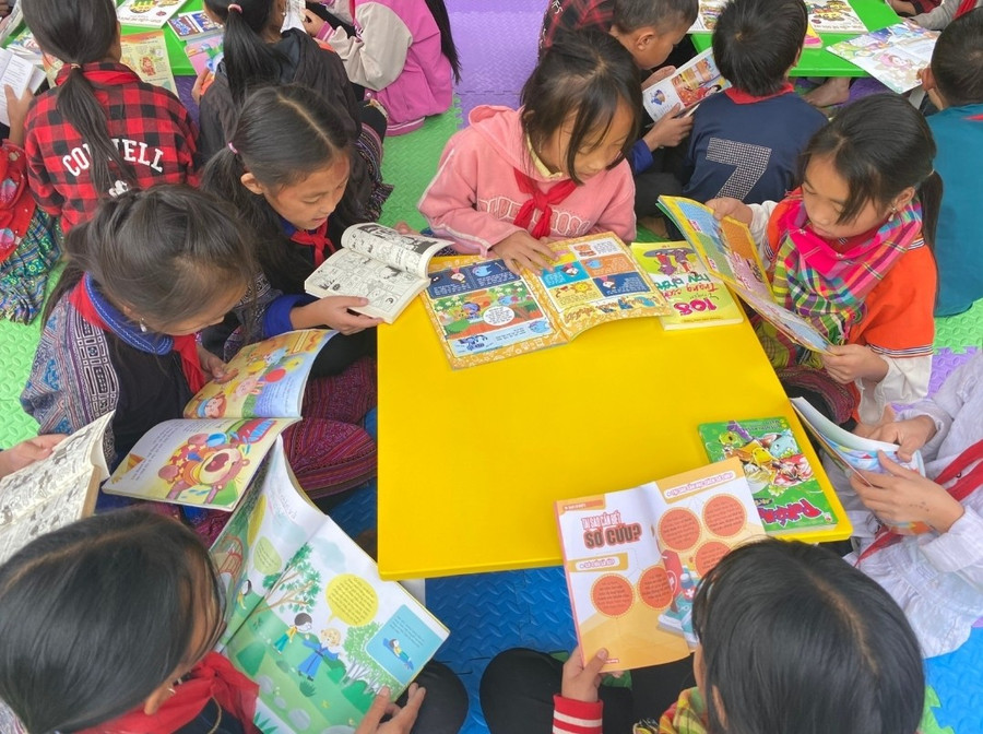 Học sinh trường PTDTBT Tiểu học & THCS Mồ Dề đọc sách, truyện trong khuôn viên trường học.