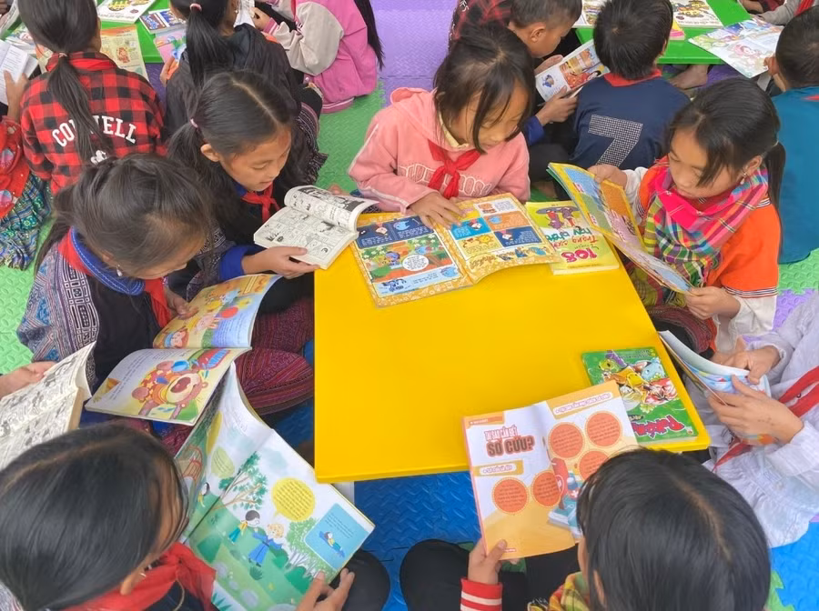 Học sinh trường PTDTBT Tiểu học & THCS Mồ Dề đọc sách, truyện trong khuôn viên trường học.