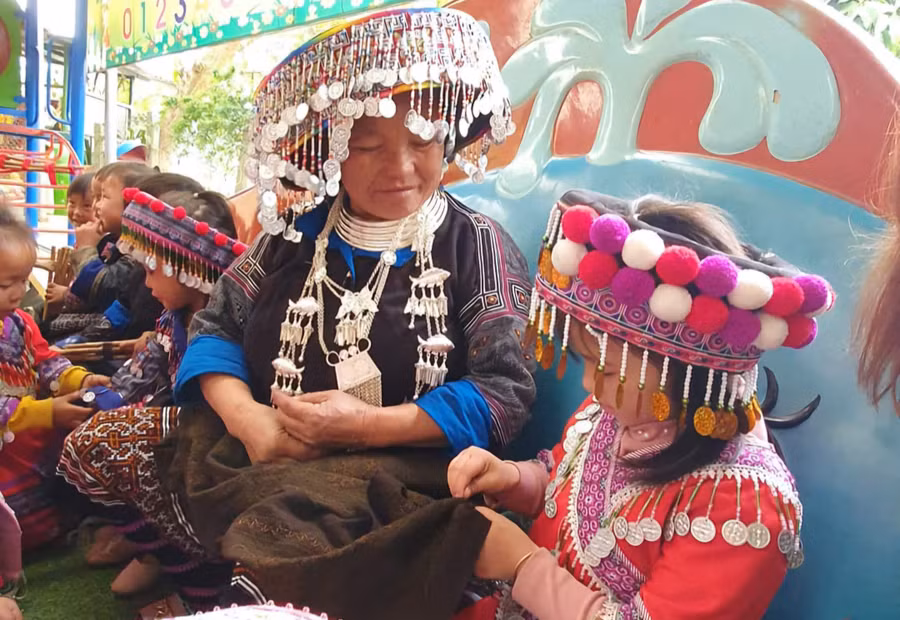 Các em học sinh trường Mầm non Bông Sen, huyện Trạm Tấu trải nghiệm thêu váy, giữ gìn bản sắc văn hóa. (Ảnh: ĐVCC)