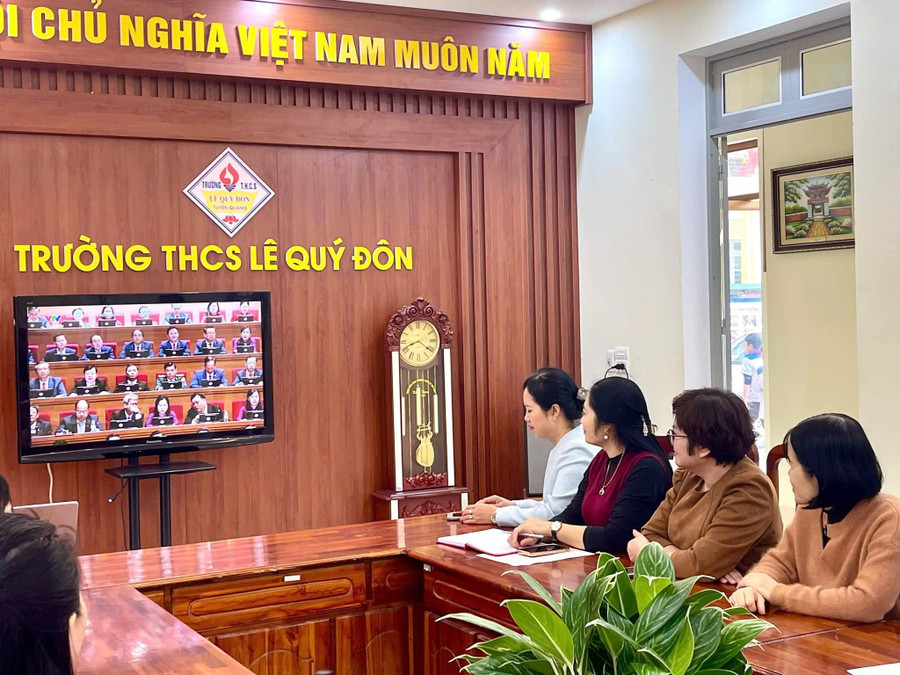 Các giáo viên Trường THCS Lê Quý Đôn theo dõi trực tiếp Đại hội XIV của Đảng qua màn hình ti vi.