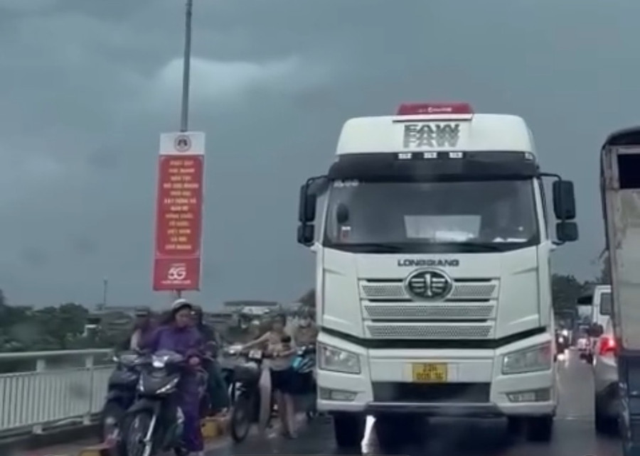 Ô tô che chắn cho các xe máy qua cầu trong mưa dông, gió lớn tại Tuyên Quang.