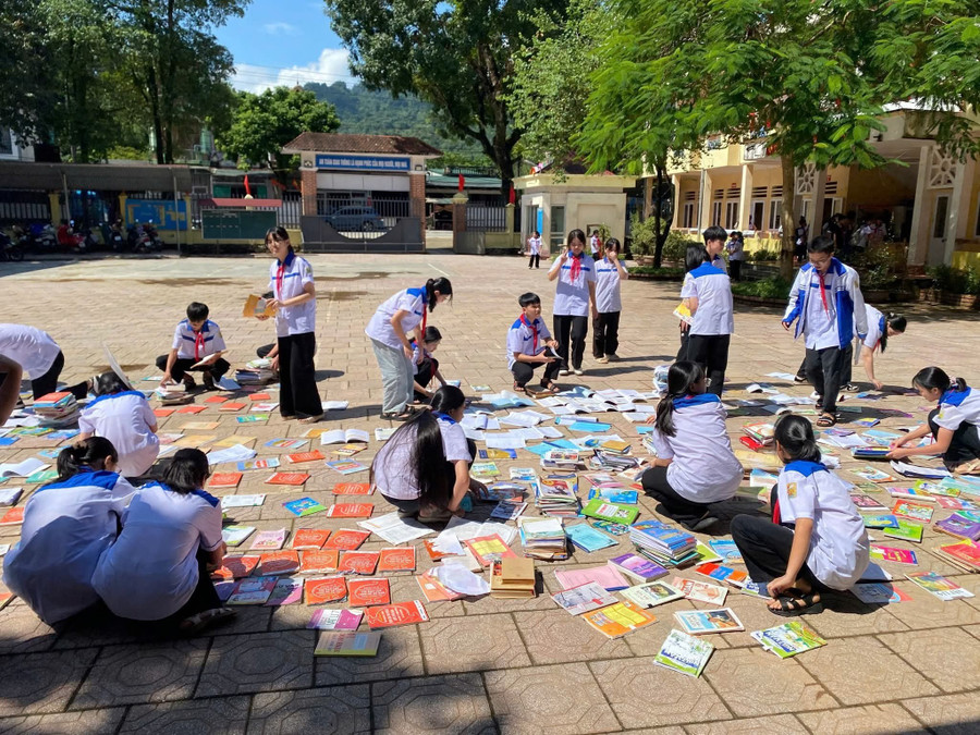 Học sinh Trường THCS Lý Tự Trọng cặm cụi phơi những cuốn sách còn phục hồi được.