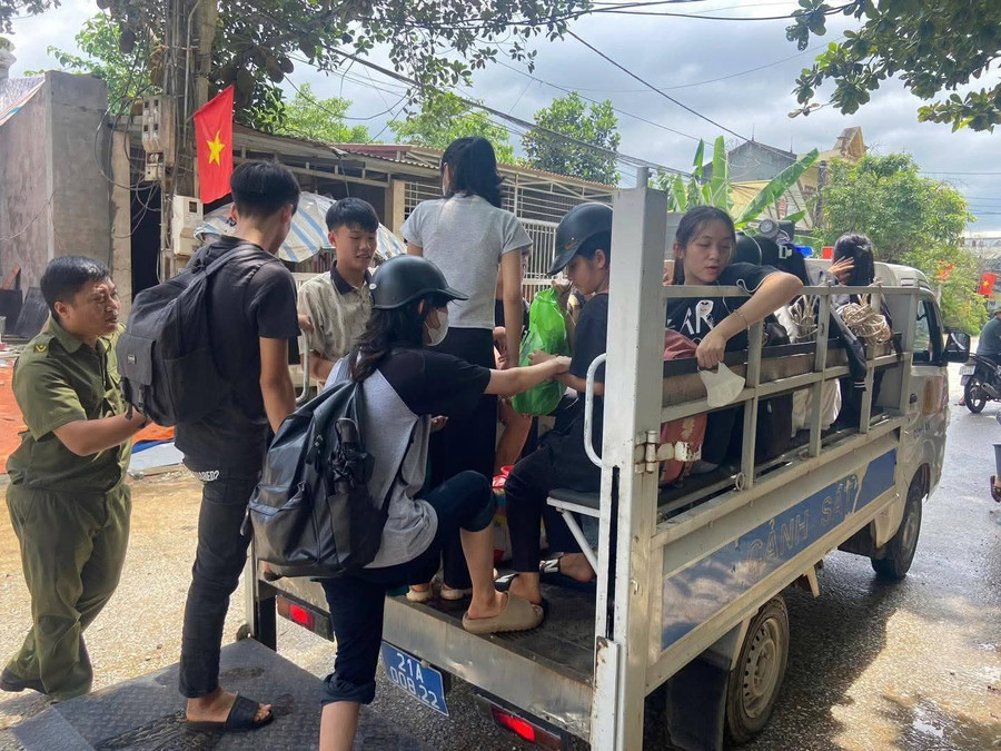 Các em học sinh tại xã Yên Thế, huyện Lục Yên đến điểm thi làm thủ tục bằng xe của công an xã. (Ảnh: CAYB)