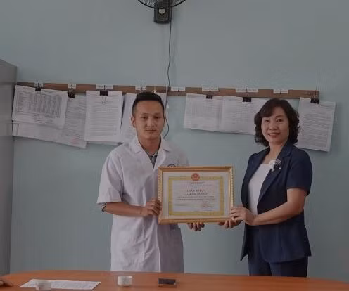 Bà Lương Thị Xuyến, Phó chủ tịch UBND huyện Mù Cang Chải, tỉnh Yên Bái tặng giấy khen của UBND huyện cho bác sĩ Giàng A Vinh.