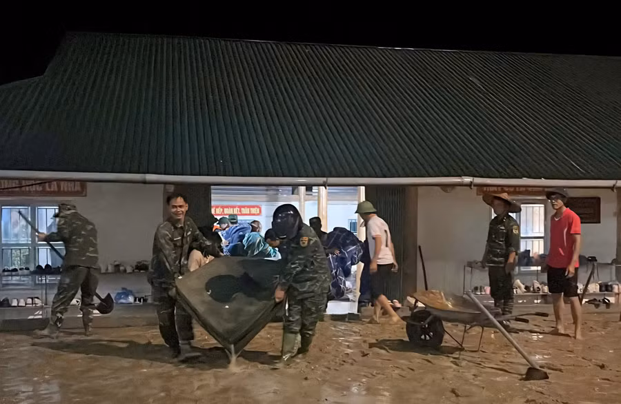 Lực lượng chức năng khắc phục khi lũ tràn vào trường.