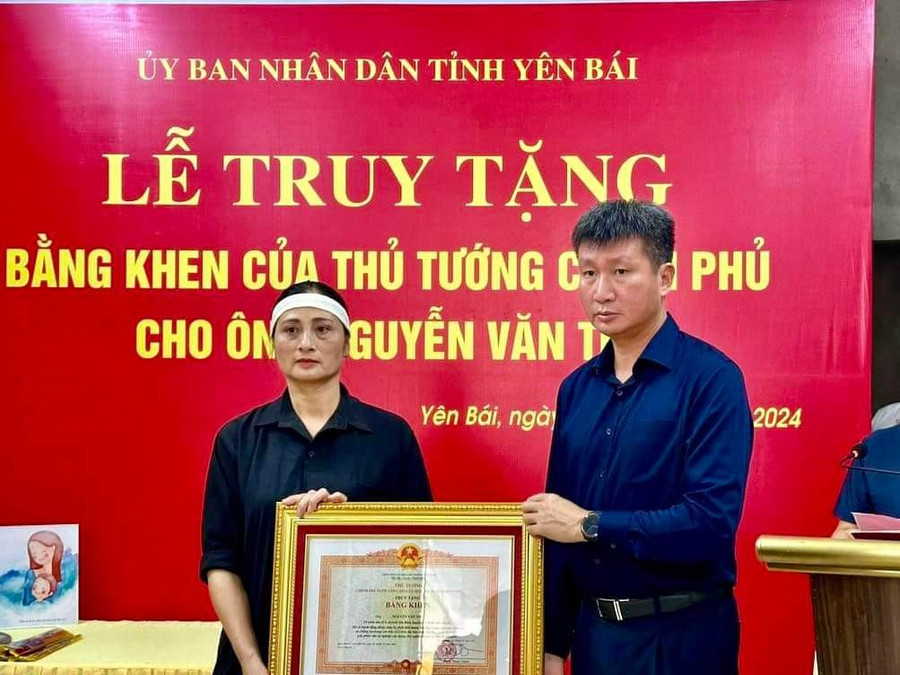 Ông Trần Huy Tuấn, Chủ tịch UBND tỉnh Yên Bái trao Bằng khen của Thủ tướng cho đại diện gia đình ông Nguyễn Văn Thi.