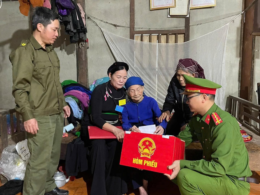 Lực lượng Công an Tuyên Quang hỗ trợ những cử tri già yếu thực hiện quyền bầu cử. (Ảnh: CATQ)