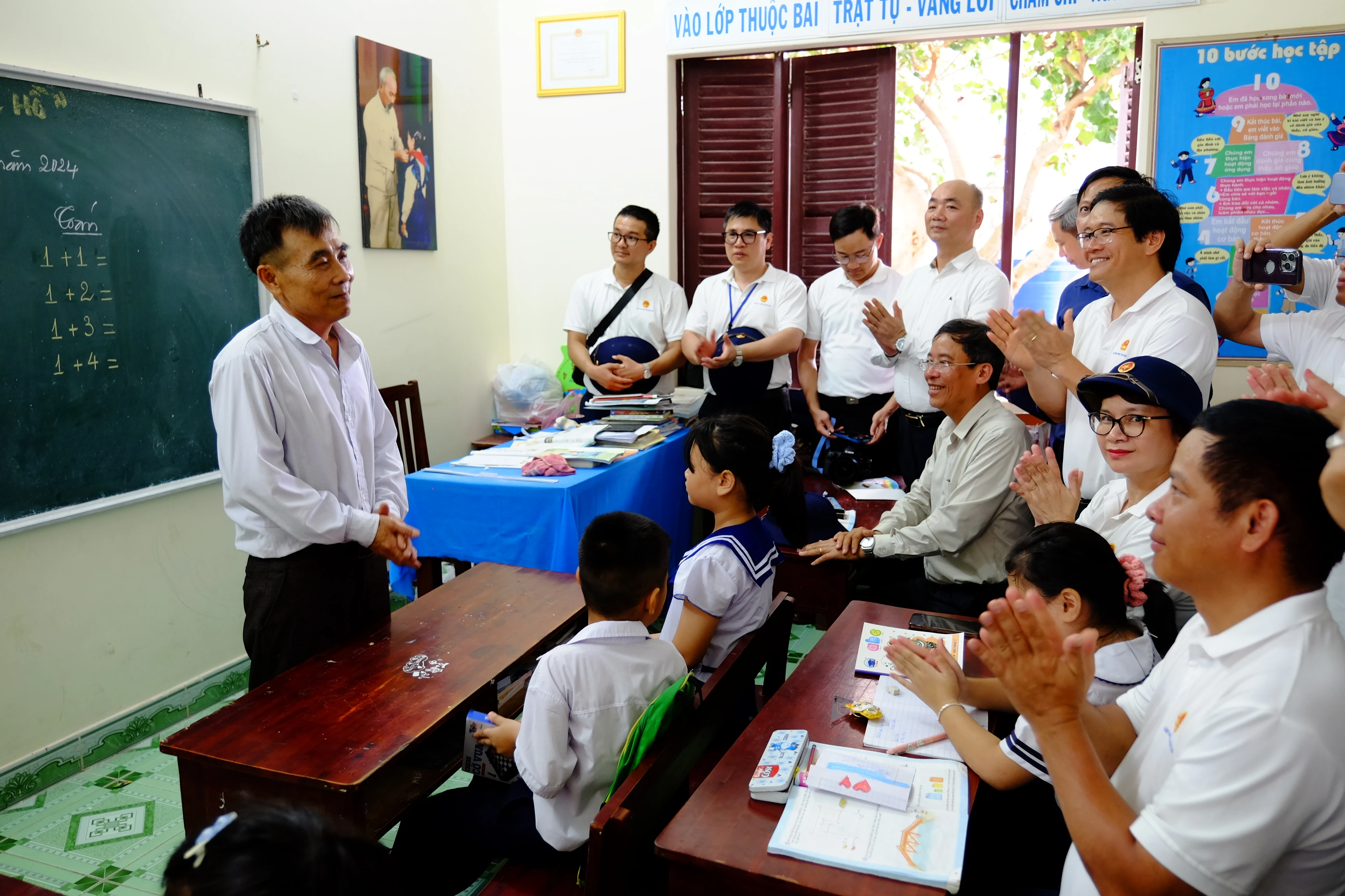 Thầy Lê Xuân Hạnh, giáo viên nhà trường, chia sẻ với đoàn công tác về những thuận lợi, khó khăn trong việc dạy và học tại Trường Sa. Sinh năm 1971, thầy vô cùng bất ngờ khi biết tin được cử ra đảo theo diện bổ sung vào tháng 9/2023. Trước đó, thầy đã đăng ký ra đảo dù biết là tuổi không còn trẻ. Trước khi ra đảo, thầy Hạnh dạy lớp 5 trường Tiểu học Cam Phước Tây 1 (Cam Lâm, Khánh Hòa). Thầy từng có 15 năm dạy học ở điểm trường vùng sâu vùng xa. Ra dạy học ở đảo, thầy bảo mình vừa là người thầy, vừa là người ông của đám trẻ nơi đây.