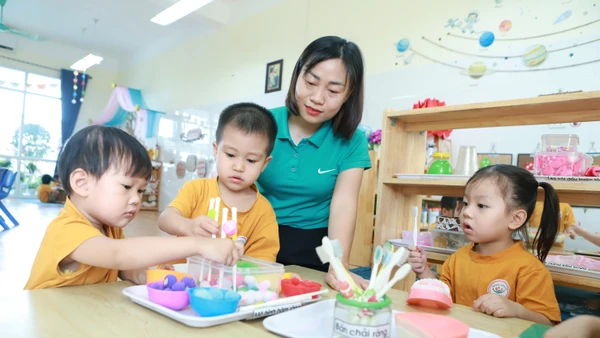 Trẻ tại Trường Mầm non An Khánh B (An Khánh, Hà Nội) trong một hoạt động góc dưới sự hướng dẫn của cô giáo. Ảnh: Đình Tuệ