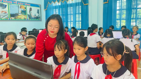 Cô giáo Trần Thị Huệ hướng dẫn học sinh thực hành môn Tin học. Ảnh: Đăng Đức