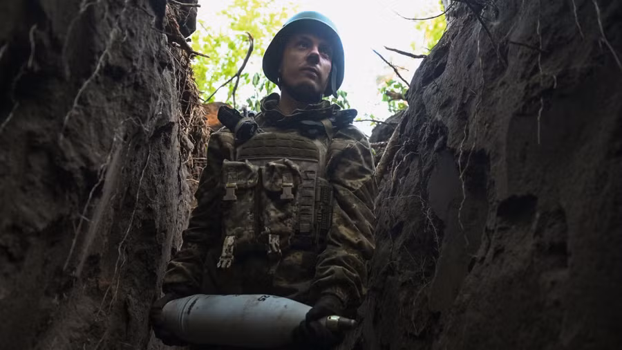 Binh sĩ Ukraine mang theo một quả đạn pháo trên tuyến đầu ở vùng Donestk.