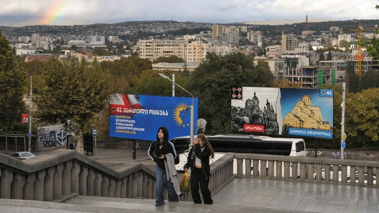 Mọi người đi ngang qua các biển quảng cáo của đảng Giấc mơ Georgia cầm quyền ở Tbilisi, Georgia, ngày 25/10/2024.