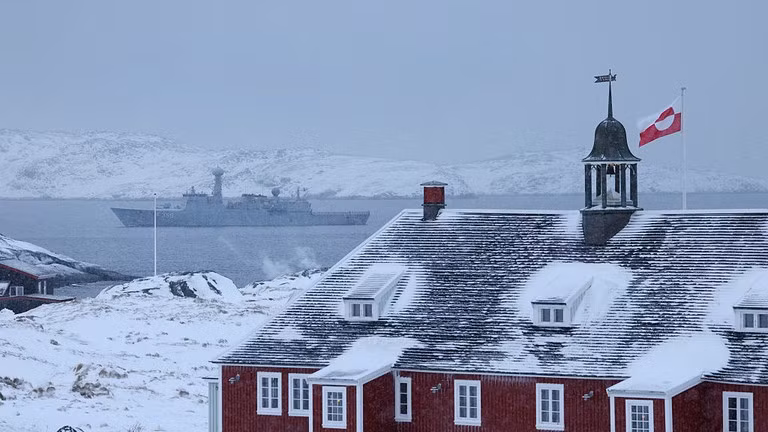 Lá cờ Greenland tung bay trên một tòa nhà khi tàu khu trục của Hải quân Đan Mạch tuần tra tại Nuuk, Greenland.