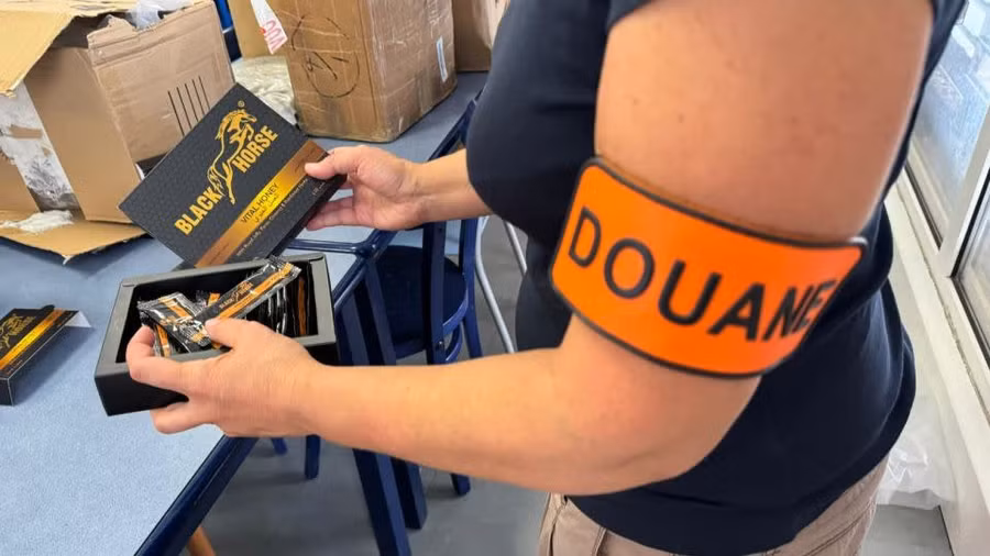 Một quan chức hải quan Pháp chụp ảnh với sản phẩm "mật ong kích thích tình dục" bị thu giữ.