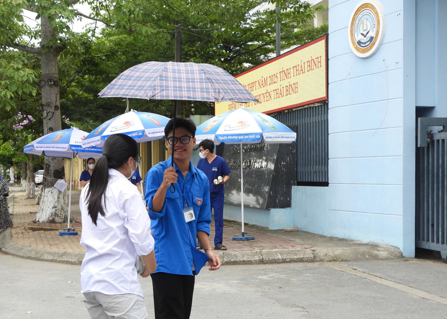 Thời tiết oi bức, tình nguyễn viên dùng ô hỗ trợ thí sinh. img-9376.jpg