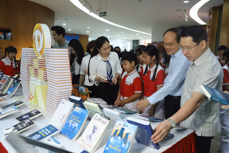 Các biểu và học sinh tham quan không gian trưng bày sách, báo tại Thư viện tỉnh Quảng Ninh. 