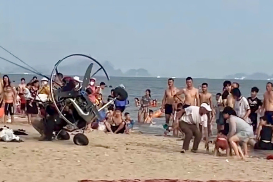 Sau khi húc vào du khách trên bãi biển, dù lượn gắn động cơ bị lật nghiêng. Ảnh cắt từ clip