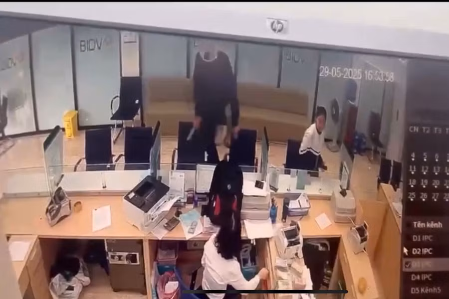 Người đàn ông trèo qua vách kính để vào bên trong cướp tiền. Ảnh cắt từ clip
