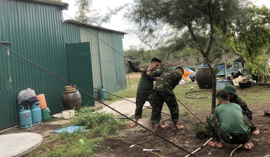 Cán bộ, chiến sĩ trên đảo Vĩnh Thực hỗ trợ người dân trên địa bàn gia cố nhà cửa.