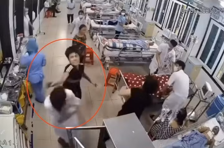 Người đàn ông dùng tay tác động vào vùng đầu, mặt nhân viên y tế. Ảnh cắt từ clip