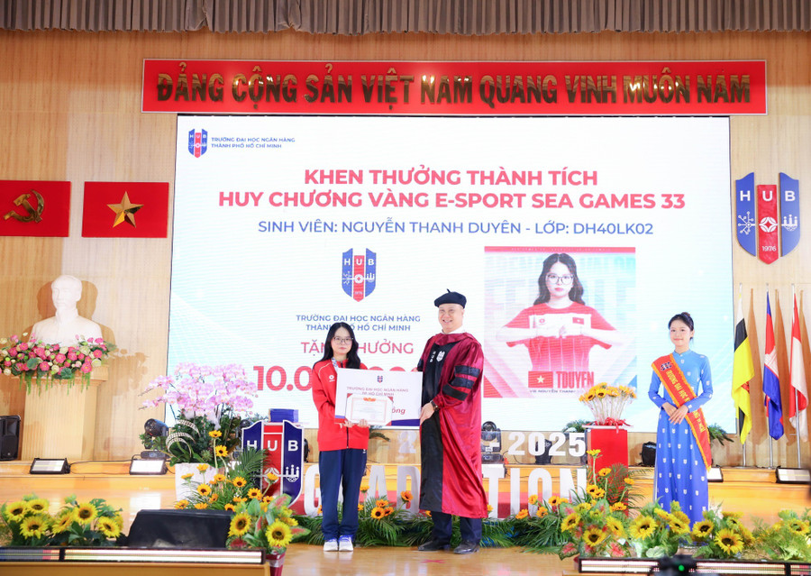 GS.TS Nguyễn Đức Trung, Hiệu trưởng Trường Đại học Ngân hàng TPHCM, trao phần thưởng của nhà trường cho Nguyễn Thanh Duyên. Ảnh: HUB