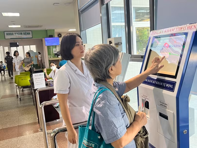 Người dân làm thủ tục khám với các ki-ốt điện tử, rút ngắn thời gian chờ đợi khám tại Bệnh viện Đa khoa Đức Giang (Hà Nội).