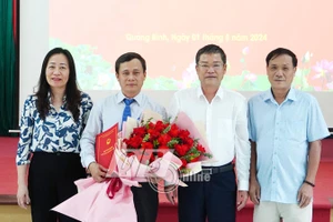 Phan Phong Phú, Phó Chủ tịch UBND tỉnh Quảng Bình trao quyết định bổ nhiệm và chúc mừng tân Hiệu trưởng Trường Cao đẳng Y tế Quảng Bình. Ảnh: Báo Quảng Bình.