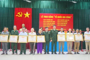 Đại tá Đinh Xuân Hướng, Phó Chủ nhiệm Chính trị Quân khu và Đại tá Trương Như Ý, Phó Chính ủy Bộ CHQS tỉnh Quảng Trị trao Bằng "Tổ quốc ghi công" cho thân nhân các gia đình liệt sĩ.