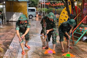 Bộ đội tham gia quét dọn vệ sinh khuôn viên trường học.