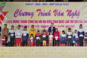 Phóng viên Báo Giáo dục và Thời đại và lãnh đạo địa phương tặng quà đến học sinh trên địa bàn.