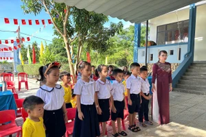 Học sinh đảo Cồn Cỏ hát quốc ca cùng cô giáo trong lễ khai giảng.