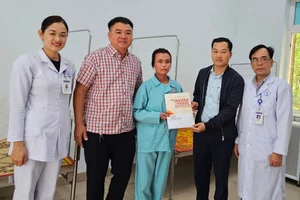 Phóng viên Báo GD&TĐ trao quà bạn đọc đến cô giáo Trần Thị Thương.