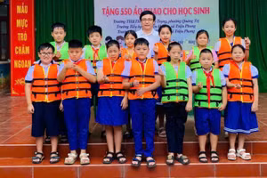 Trao tặng áo phao cho học sinh vùng chịu ảnh hưởng của lũ lụt.