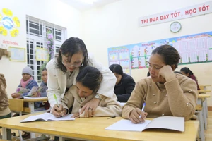 Cô Trần Thị Châu giúp học viết viết từng nét chữ.